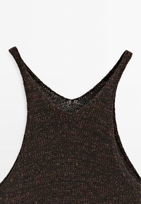 Canottiera lavorata a maglia in marrone scuro con scollatura a V e spalline larghe. Presenta un motivo texturizzato e dettagli di cucitura aperta lungo il collo.