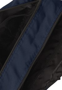 Borsa blu navy con zip, dotata di un esterno liscio e resistente. L'interno è foderato in nero con una tasca a rete. Caratterizzata da due cerniere per un facile accesso.