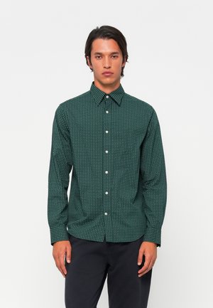 Donkergroene knoopshirt met een wit geometrisch patroon, lange mouwen en een puntige kraag. Gemaakt van een lichte stof, met een rechte zoom.