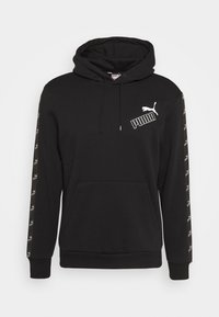 Felpa nera con cappuccio e tasca a canguro, cappuccio regolabile con cordino e logo Puma bianco sul petto. Presenta accenti a righe lungo le maniche.