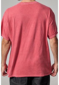 Czerwona, krótko rękawowa bawełniana koszulka o luźnym kroju. Miękka faktura, widoczne szwy i gładki brzeg. Widok z tyłu ukazuje prosty design.