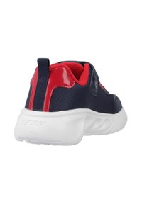 Baskets bleu marine et rouge avec une semelle blanche, intérieur rembourré rouge, et un onglet noir au talon, vues de l'arrière.