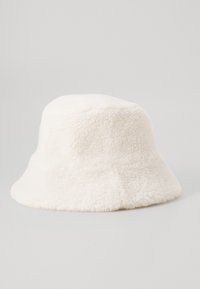 Fehér, bolyhos vödörsapka puha anyagból, széles, lefelé lejtő karimával, látható fémrészek vagy minták nélkül.