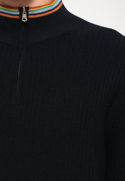Pullover a coste di colore blu navale con colletto alto, dotato di cerniera e un accento a righe multicolori sul colletto.