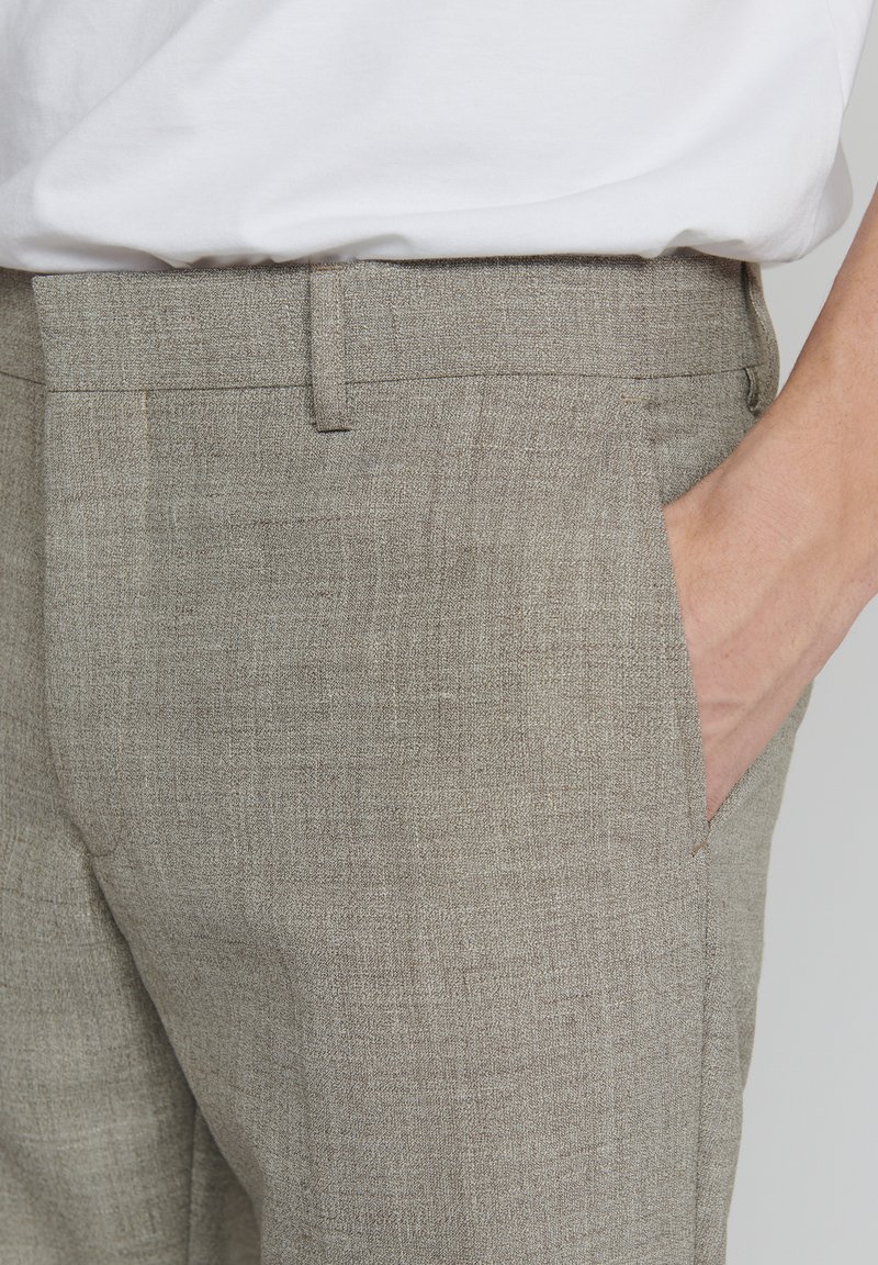 Jasnoszare lniane spodnie o teksturowanym wykończeniu, z kieszenią boczną oraz płaskim pasem w talii. Odpowiednie do noszenia na co dzień lub w semi-formalnych okolicznościach.