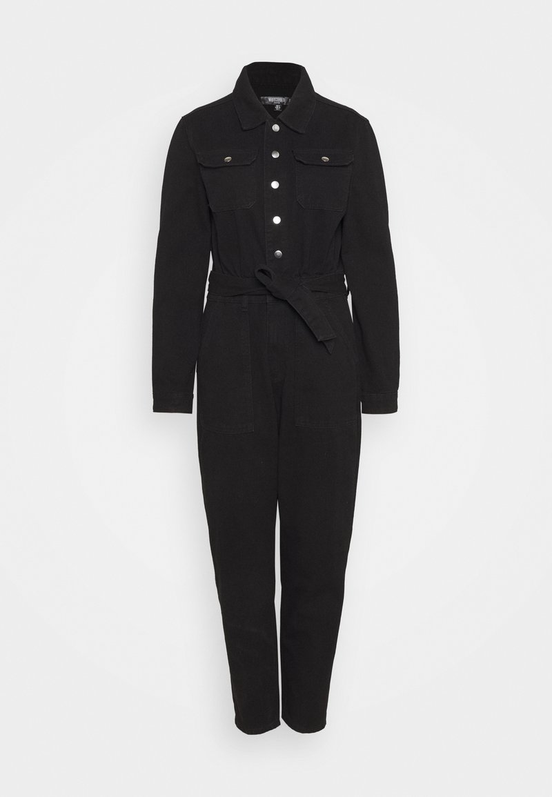Combinaison noire à manches longues avec boutons argentés sur le devant, poches poitrine, col à revers, ceinture à nouer à la taille et pantalon à jambes droites.