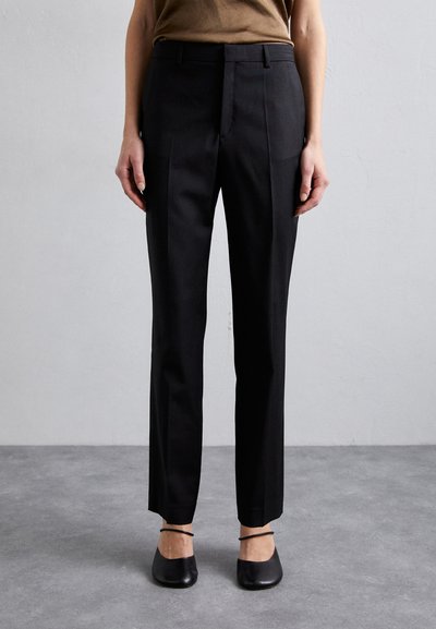 Schwarze, maßgeschneiderte Hose mit geradem Bein, aus glattem Stoff. Sie verfügt über Vordertaschen, Gürtelschlaufen und einen Falte in der Vorderseite.