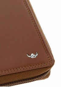 Coin de portefeuille en cuir marron avec détail de couture, petit logo argenté ressemblant à un casque à cornes, et bord visible de fermeture éclair en tissu marron.