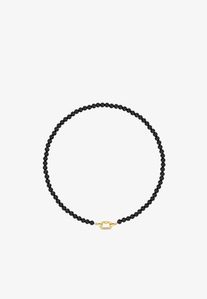 Collier de perles noires avec un fermoir ovale doré à l'avant, disposé en forme circulaire sur fond blanc.
