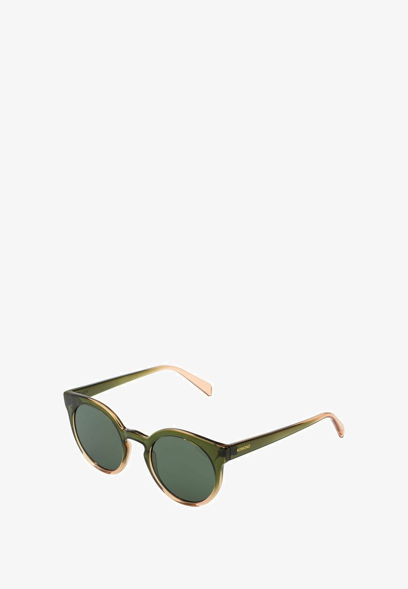 Lunettes de soleil teintées de vert avec une monture ronde, présentant des bords verts translucides et des branches marron clair, complétées par un discret logo doré.