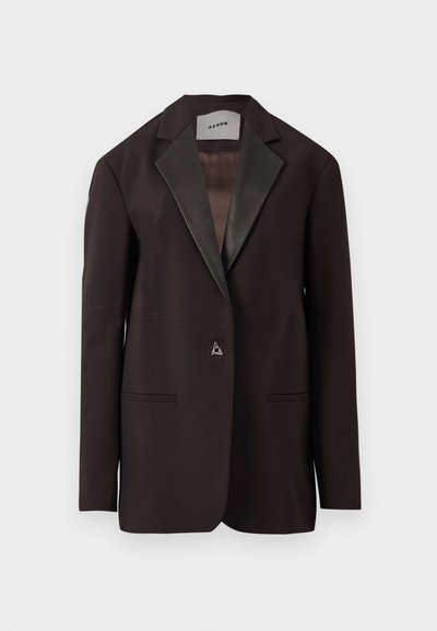 Blazer noir avec un revers en satin, comportant deux poches avant et une fermeture à bouton unique. Design ajusté avec une coupe structurée.