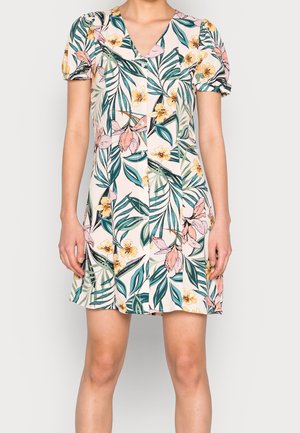 Krótka kwiatowa sukienka z zielonym i żółtym nadrukiem liści i kwiatów, krótkie bufiaste rękawy i dekolt w serek na osobie.