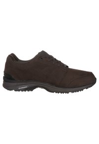 Scarpe sportive marroni realizzate in materiale simile al suede, con una tomaia texture, punta arrotondata e dettagli neri sul tallone e sulla suola.