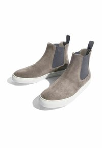 Botas de tobillo de ante gris con inserciones elásticas, parte superior lisa, suelas de goma blanca y tiradores para facilitar su uso.