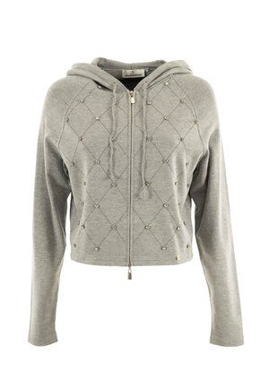 Un hoodie gris court en tissu doux, avec une fermeture éclair à l'avant, un motif de piqûre en losange et des clous décoratifs répartis sur l'ensemble.
