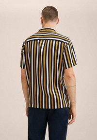 Camisa de manga corta con rayas verticales en amarillo, azul marino y blanco, con dobladillo recto y ajuste relajado.