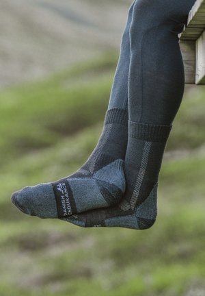 Dunkelblaue gemusterte Socken mit einem geometrischen Design, hergestellt aus einem weich strukturierten Material, mit einem gerippten Bündchen und einem Logodetail an der Seite.