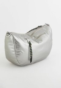 Sølv, polstret skuldertaske med en rund form. Har dobbelte lynlåse og farverige flettrådsdetaljer. Glat, skinnende tekstur.