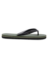 Mustat flip-flop-sandaalit, joissa on vihreä kumipohja, teksturoitu alustani sekä mustat hihnat logolla. Tasainen muotoilu ja matala profiili.