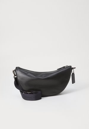 Sac à bandoulière en cuir noir en forme de croissant avec sangle en tissu ajustable et fermeture éclair, sur fond blanc.