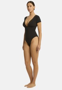Costume da bagno intero nero con maniche corte, scollatura a V profonda, gamba alta e texture liscia. Presenta un design aderente per una silhouette slanciata.