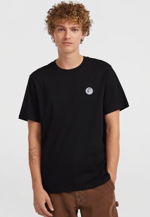 Sort bomulds T-shirt med korte ærmer, prydet med et cirkulært hvidt logo på venstre bryst. Glat tekstur, afslappet pasform og rund halsudskæring.