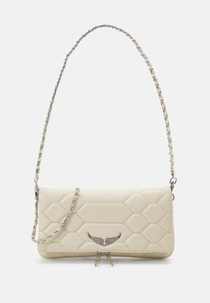 Bolso de mano acolchado en crema con un patrón hexagonal, herrajes en plata y una correa de cadena. Presenta un emblema alado y un cierre doble con cremallera.