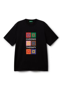 Camiseta negra de manga corta con gráficos cuadrados coloridos y el texto "TERAPIA DEL COLOR" en letras blancas en el centro.