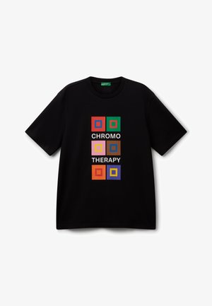 Camiseta negra de manga corta con gráficos cuadrados coloridos y el texto "TERAPIA DEL COLOR" en letras blancas en el centro.