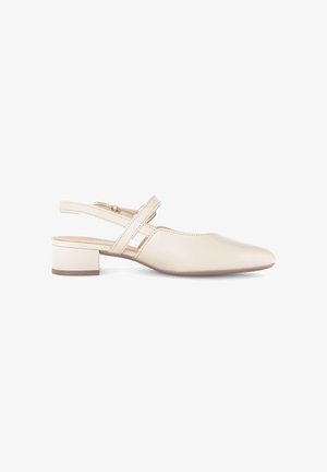 Beige lage slingback-schoen met hak, puntige neus, gekruiste bandjes en gespsluiting, weergegeven op een witte achtergrond.