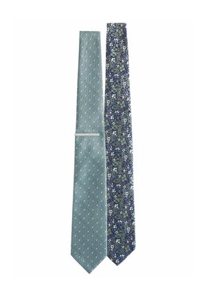 Two ties: one light blue with small white polka dots, and one dark blue with a floral pattern in green and white.