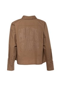 Bruine cropped shirt met lange mouwen, voorzien van witte borduursel met de tekst "WAT JE OOK DENKT!" op de achterkant. Met knopen bij de manchet.