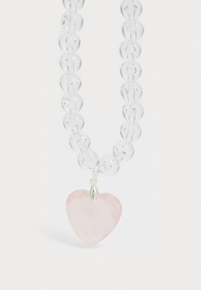 Selge helmed kaelakee, mis sisaldab faceteeritud roosa südame ripatsit, hõbedast lisandeid, sileda tekstuuri ja lihtsat, elegantset disaini.