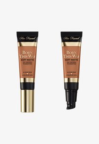 Tubes de fond de teint Too Faced en marron foncé, avec une finition mate douce. Un tube a un embout pompe, l'autre un capuchon à vis standard. Accents noir et or.