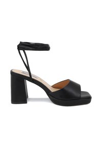 Sandal con tacco nero, con piattaforma, punta aperta e design a incrocio delle cinghie. Presenta una cinghia alla caviglia testurizzata e un tacco a blocco.