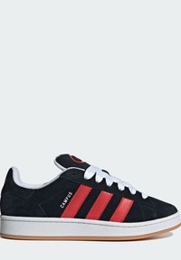 Sneakers in suede nero con strisce in pelle rossa, lacci bianchi e suola in gomma bianca testurizzata. Presentano il logo sulla linguetta e sul tallone.