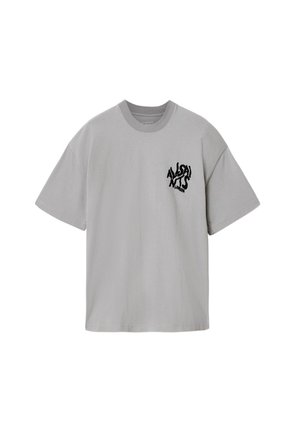 Lichtgrijs T-shirt met korte mouwen en een ronde hals, met daarop zwarte vervormde tekst "ALSAI NTS LONDON" op de linkerborst.