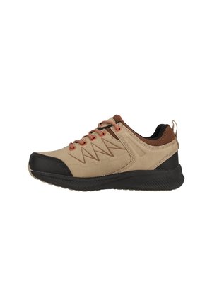 Chaussure de sport beige et noire en tissu texturé, avec des accents marron, un design en zigzag sur le côté, et une semelle en caoutchouc robuste.