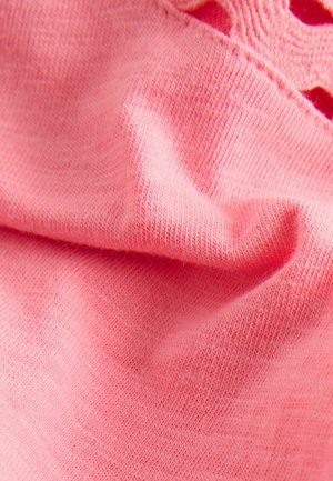 Pink fabric showing a soft, textured knit with subtle variations in thread density. Features a smooth surface with slight folds.