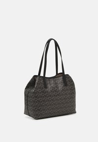 Mustakangan laukku, jossa on geometrinen kuvio, valmistettu tekstuuripinnoitteisesta kankaasta. Varustettu kahdella pitkällä kahvalla ja tilavalla muotoilulla.