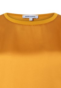 Gelbes Satin-Oberteil mit Rundhalsausschnitt. Der Stoff wirkt glatt und glänzend und zeichnet sich durch ein einfaches Design ohne zusätzliche Muster aus.