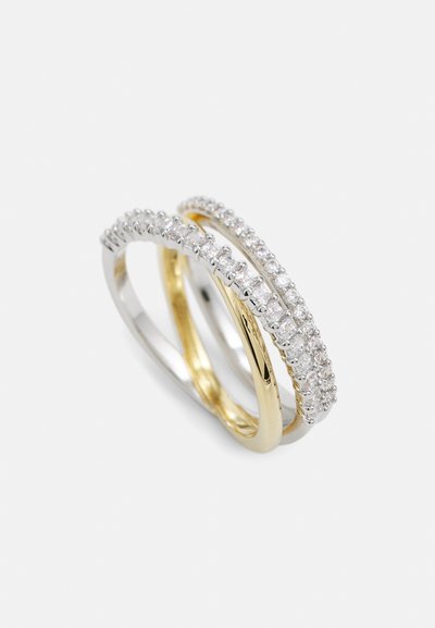 Deux bagues, l'une en or jaune et l'autre en argent, chacune ornée d'une rangée de petites pierres claires le long de l'anneau, présentant une finition lisse.