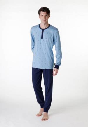 Completo loungewear in cotone composto da una maglietta a maniche lunghe azzurra chiara con accenti blu navy e un motivo stampato, abbinato a pantaloni blu navy.
