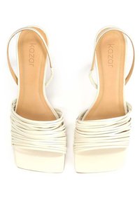Sandales à talons blancs avec un design de lanières superposées, bout carré et une finition lisse. Les semelles intérieures sont beige avec une empreinte de logo.