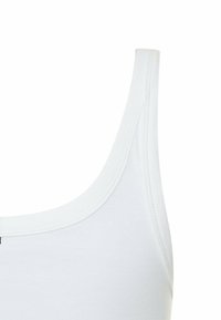 Weißes Baumwoll-Tanktop mit rundem Ausschnitt und dünnen Trägern. Glatte Textur mit verstärkten Nähten für Langlebigkeit.