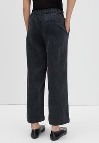 Pantaloni a gamba larga in corduroy grigio scuro con vita elasticizzata, dotati di una tasca posteriore e una finitura morbida e testurizzata.