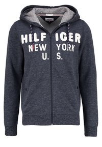 Felpa con zip blu navy con fodera grigia, decorata con la scritta bianca "HILFIGER NEW YORK U.S." e concorde decorative sul cappuccio. Tessuto morbido.