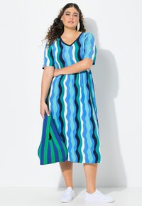Vestido de manga corta y escote en V con un patrón de rayas onduladas en varios tonos de azul y verde, confeccionado en una tela ligera.