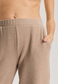Beige sweatpants gemaakt van zachte stof, met een elastische tailleband, zijzakken en een relaxte pasvorm met een licht gestructureerde oppervlakte.