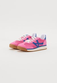 Des sneakers roses avec des accents bleus, des lacets blancs et une semelle en gomme texturée. Caractérisent des perforations et un design bas.
